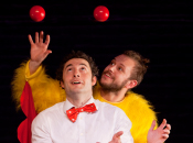 Two men juggling one with a bow tie, one in a chicken costume