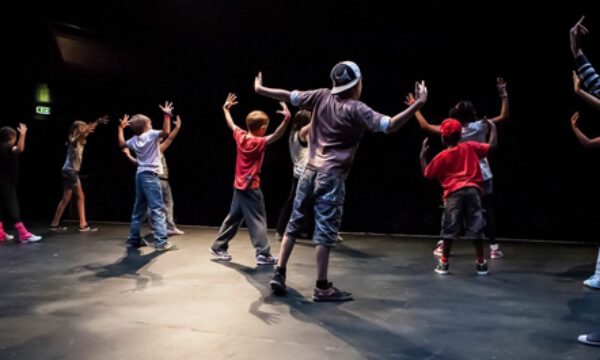 A group of young people practcising street dance on stage