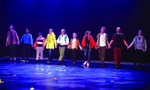 People holding hands in a line on stage