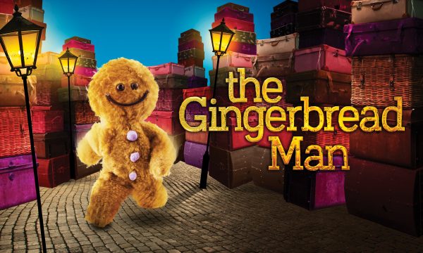 A fluffy, cartoon gingerbread man runs down a cobbled, lamplit street. Text on the right saying "The Gingerbread Man".