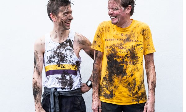 Daniel Bye and Boff Whalley in running attire. They are laughing and covered in mud.