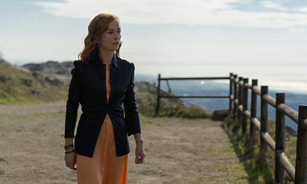 Woman stood on a dirt path near cliffs