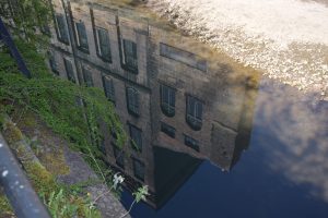 Photo of a building reflected in water.