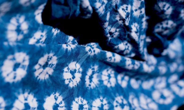 A piece of tie dyed cloth, it is dark blue with white circles