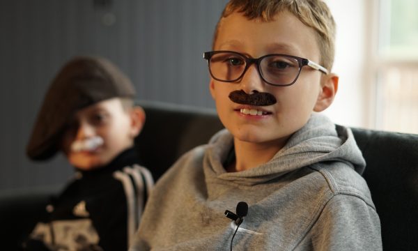 Two primary school age boys wearing fake moustaches