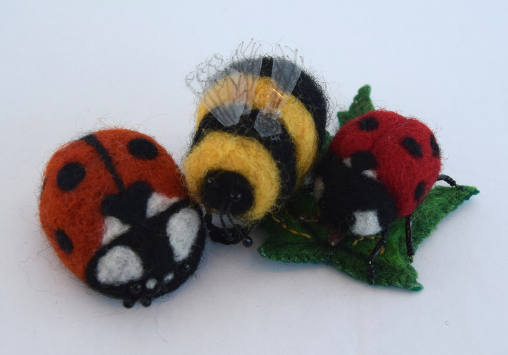 An arrangement of needle felt ladybirds and bumblebees.