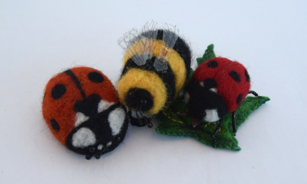 An arrangement of needle felt ladybirds and bumblebees.