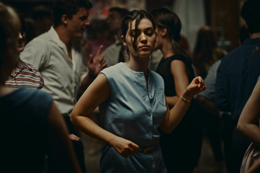 A woman dances in the middle of a crowd of other people
