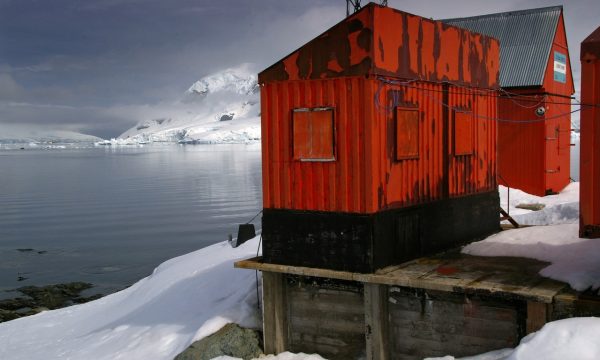 Red corrugated buildings in a snowy, icy landscape