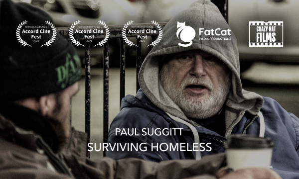 Text reading 'Paul Suggitt Surviving Homeless', Crazy Hat Films, and Accord Cine Fest selections. A grey-bearded man in a grey hoodie and blue jacket is speaking to a man in a brown jacket and black hat.