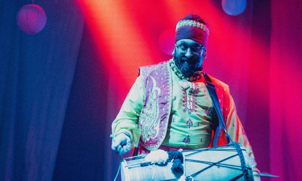 Dhol drummer under colourful lights