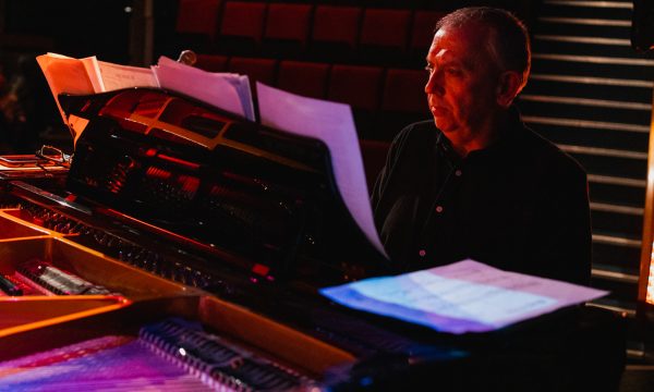 Jeremy from Pocket Jazz Orchestra playing piano on stage