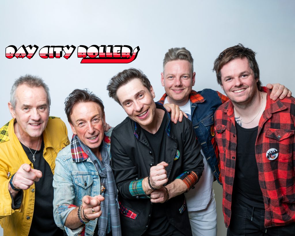 5 members of Bay City Rollers smiling and looking happy
