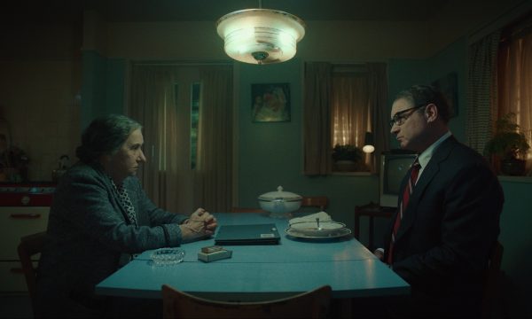 Helen Mirren portrayed as Golda Meir sat at a table smoking with Henry Kissinger