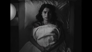 girl lying on bed awake in black and white