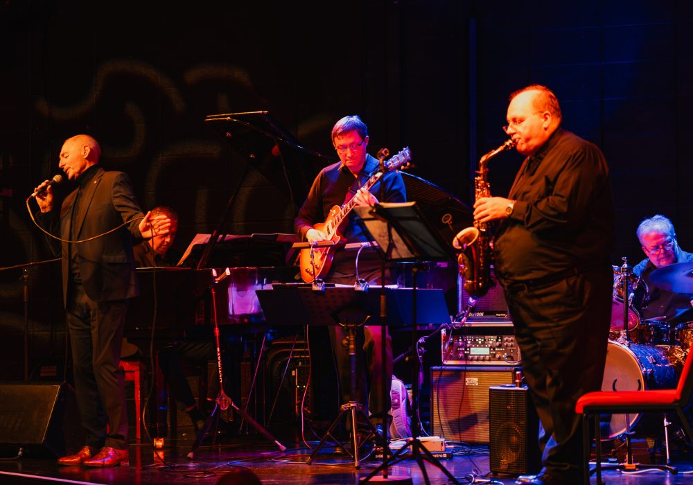 Drummer Paul, Sax player Mark, guitar player Paul, Tony Maxwell on vocals and Jeremy on piano all perform on stage