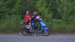 girl and boy sat on a moped