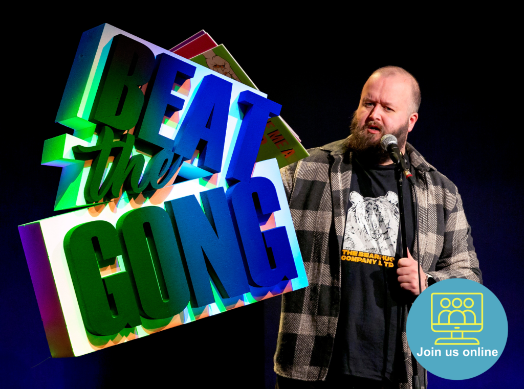 Comedian Freddy Quinne standing to the right of an illuminated Beat the Gong logo.