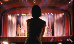 A person stood in front of a stage over-seeing acts.