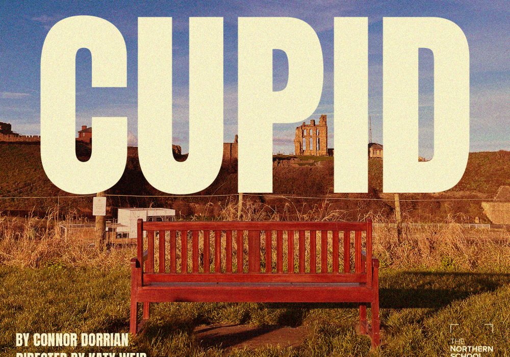 A bench with some historical building ruins in the background. Text reads: CUPID by Connor Dorrian, directed by Katy Weir