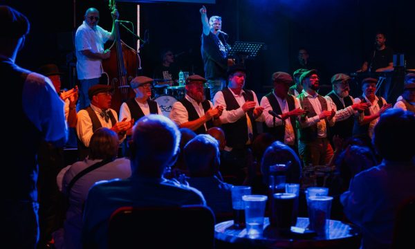 Mike McGrother and Infant Hercules male choir on stage