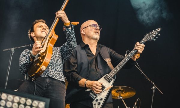 Two guitarists from Wishbone Ash including front person Andy Powell shred guitar together on stage