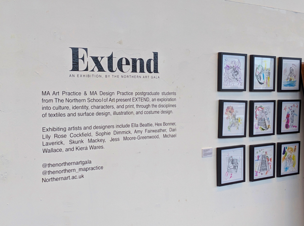 A photo of a white gallery wall, featuring exhibiton text, and nine framed prints.