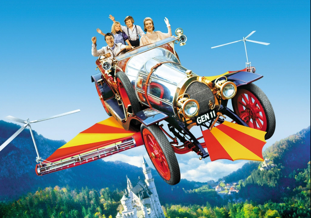 The four main characters, Mr Potts, his two children, Jeremy & Jemima & along with Miss Truly Scrumptious gleefully wave in the flying car, Chitty