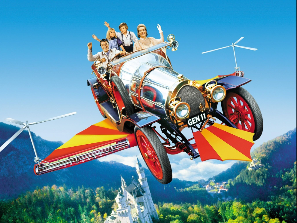 The four main characters, Mr Potts, his two children, Jeremy & Jemima & along with Miss Truly Scrumptious gleefully wave in the flying car, Chitty