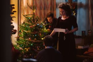 Jamie Bell, Claire Foy, and Andrew Scott decorating a Christmas tree.