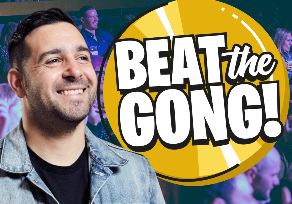Comedian Danny McLoughlin, a white man with short, dark brown hair, stands smiling next to an animated Beat the Gong logo.