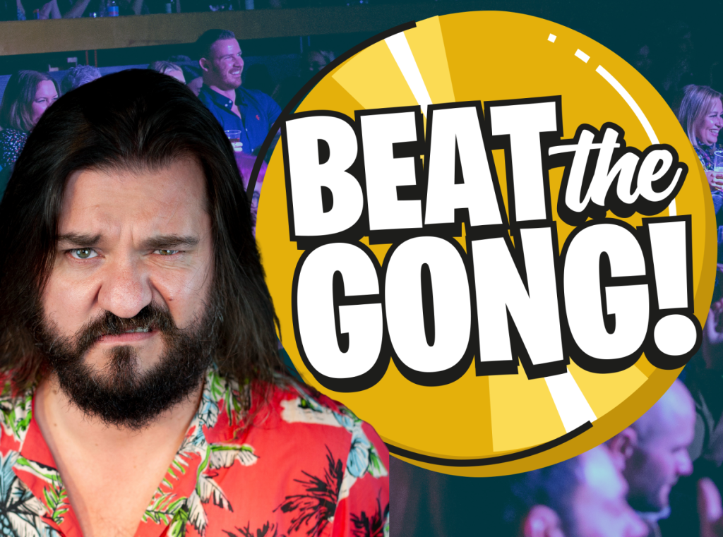 Matt Reed, a white comedian with mid-length dark brown hair, stands next to an animated Beat the Gong logo. He is looking directly into the camera and is wrinkling up his nose.
