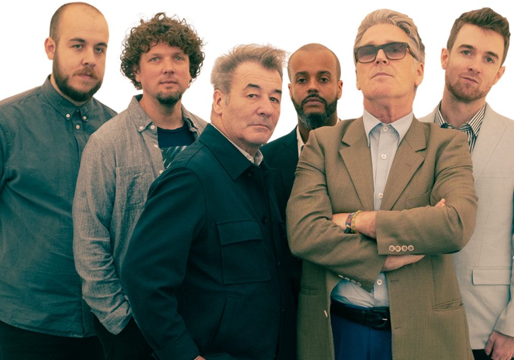 6 members of China Crisis stand together facing you