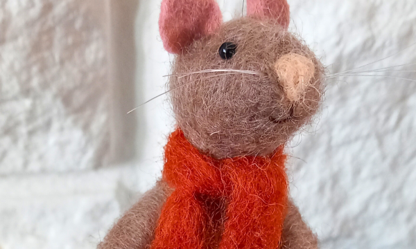 A brown, needle felt mouse wearing a red felt scarf.