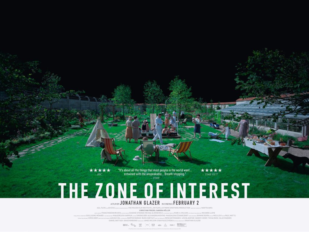 The Zone of Interest advertising poster showing people on a green lawn with tents and picnic chairs, to the left the barbed wire of Auschwitz