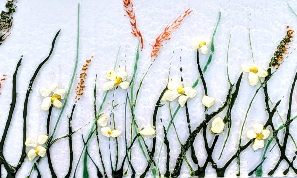 A row of delicate flowers painted on a sheet of white glass.