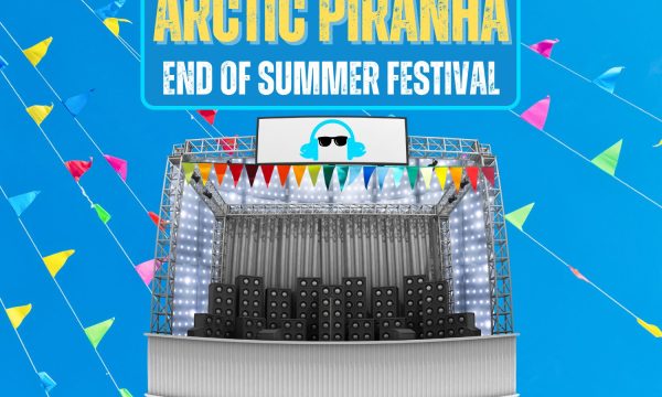 Promotional poster for 'Arctic Piranha End of Summer Festival'. The background is bright blue with colorful triangular flags. In the center is an illustration of a concert stage with speakers, lights, and a large screen showing a stylized DJ icon wearing sunglasses and headphones. The stage is decorated with multicolored pennant flags. The festival name is displayed in large text at the top, with 'Arctic Piranha' in yellow and 'End of Summer Festival' in white