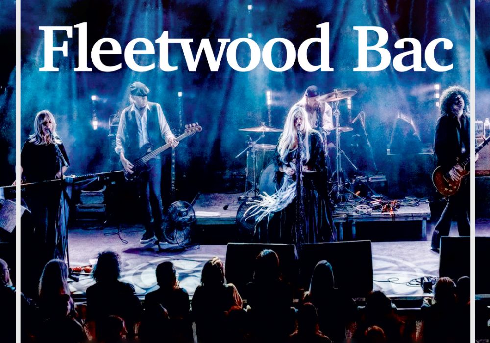 Live concert photo of Fleetwood Mac tribute band "Fleetwood Bac" performing on stage. Five musicians visible, replicating the classic Fleetwood Mac lineup. Stage bathed in blue lighting. Band name "Fleetwood Bac" displayed at top. Silhouettes of audience members visible in foreground.