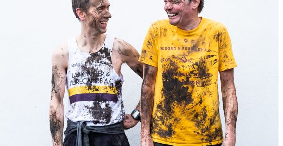 Daniel Bye and Boff Whalley in running attire. They are laughing and covered in mud.